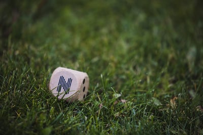 A dice with Nortal logo on it in the grass