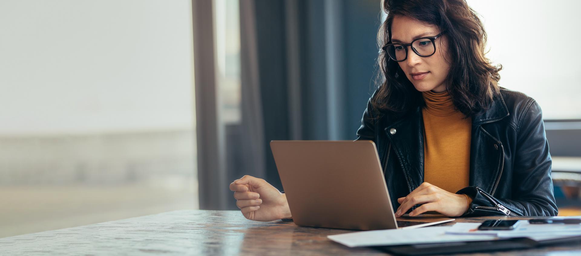 Woman with dark hair looking at laptop