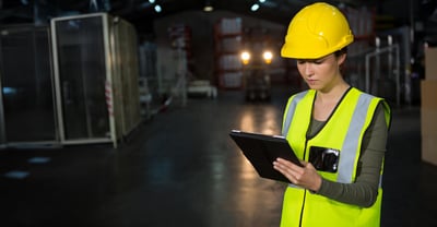 Female wearing hard hat looking at tablet