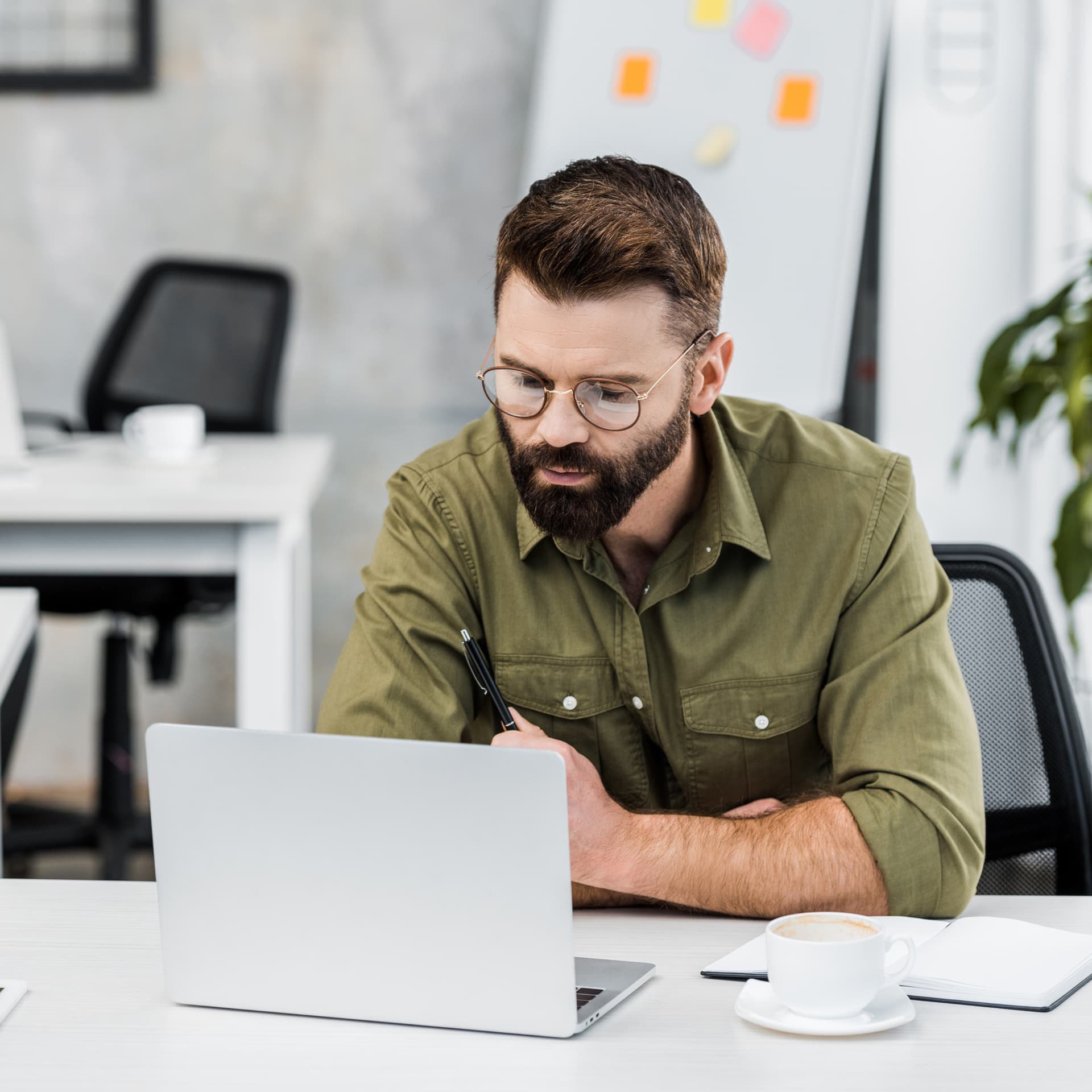 Man with glasses looking at laptop