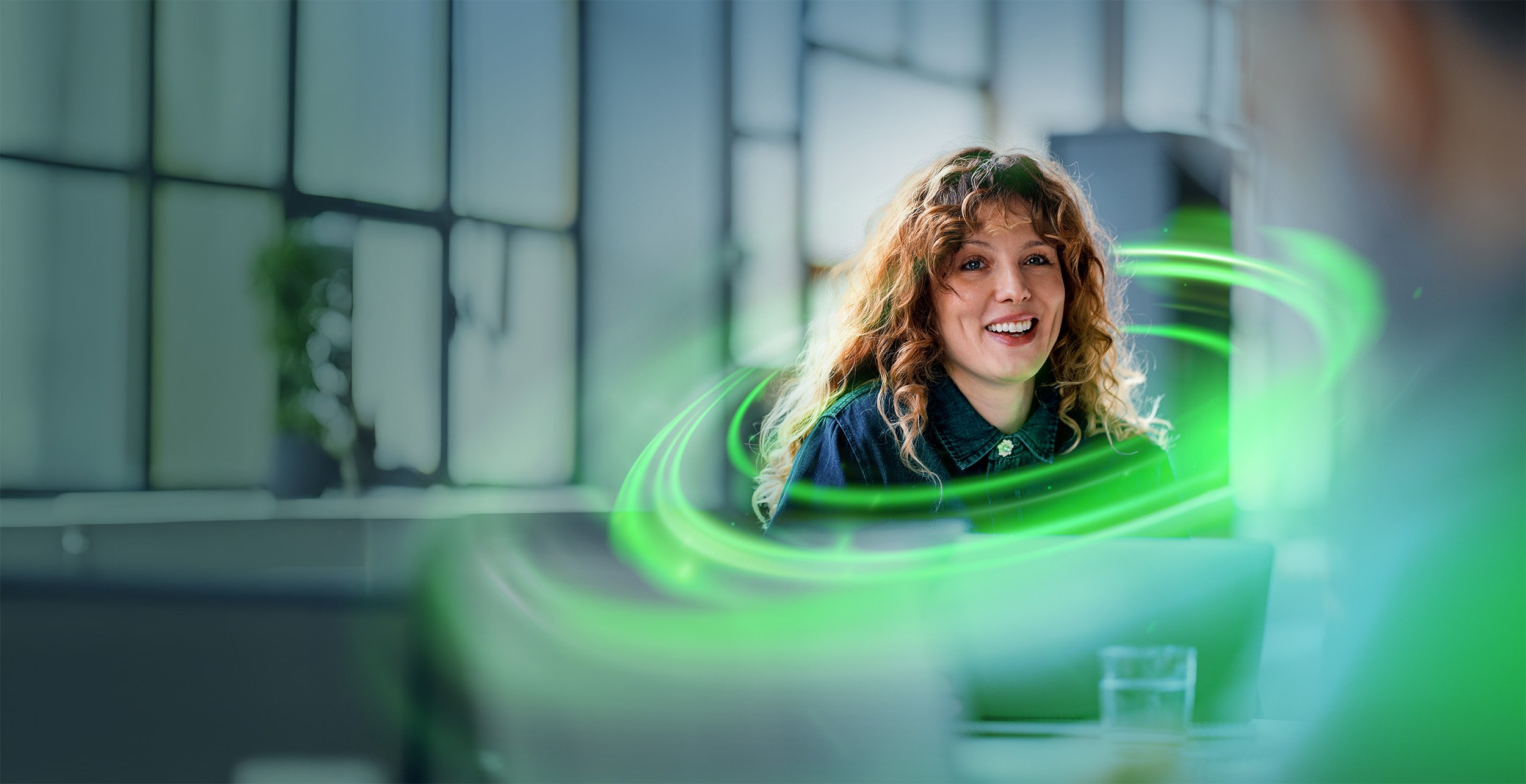 Woman sitting in the office surrounded by green Nortal AI Hack lights