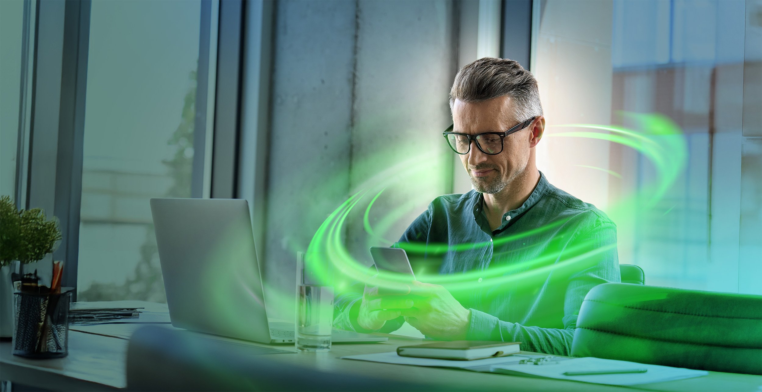 Man sitting in a office, surrounded by green lights