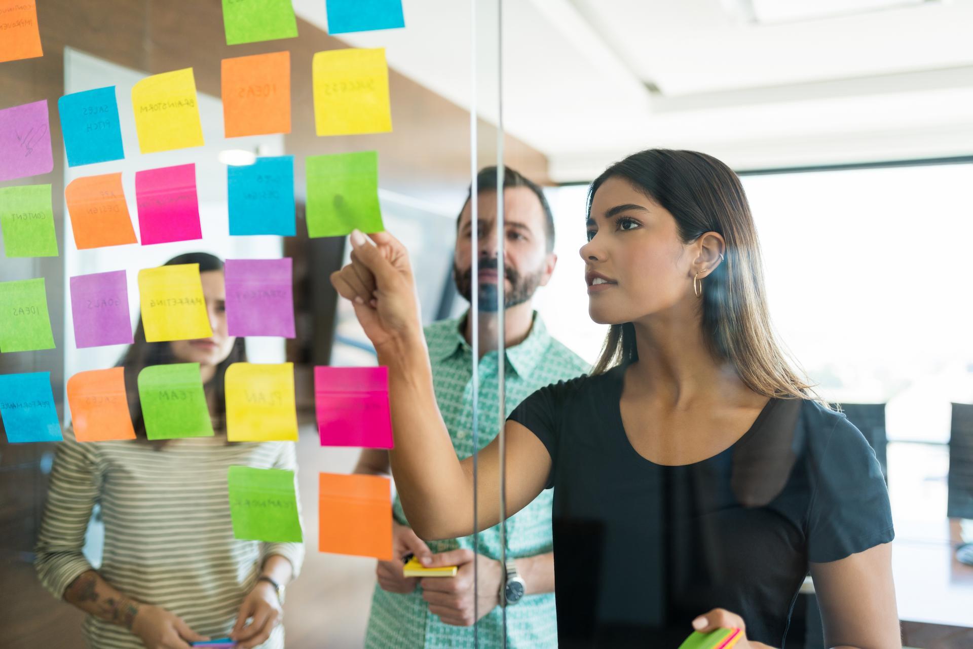 Man and woman looking at post-its on board