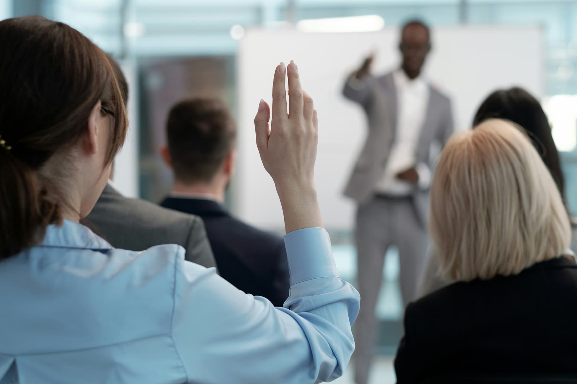Woman raising a hand in an auditorium