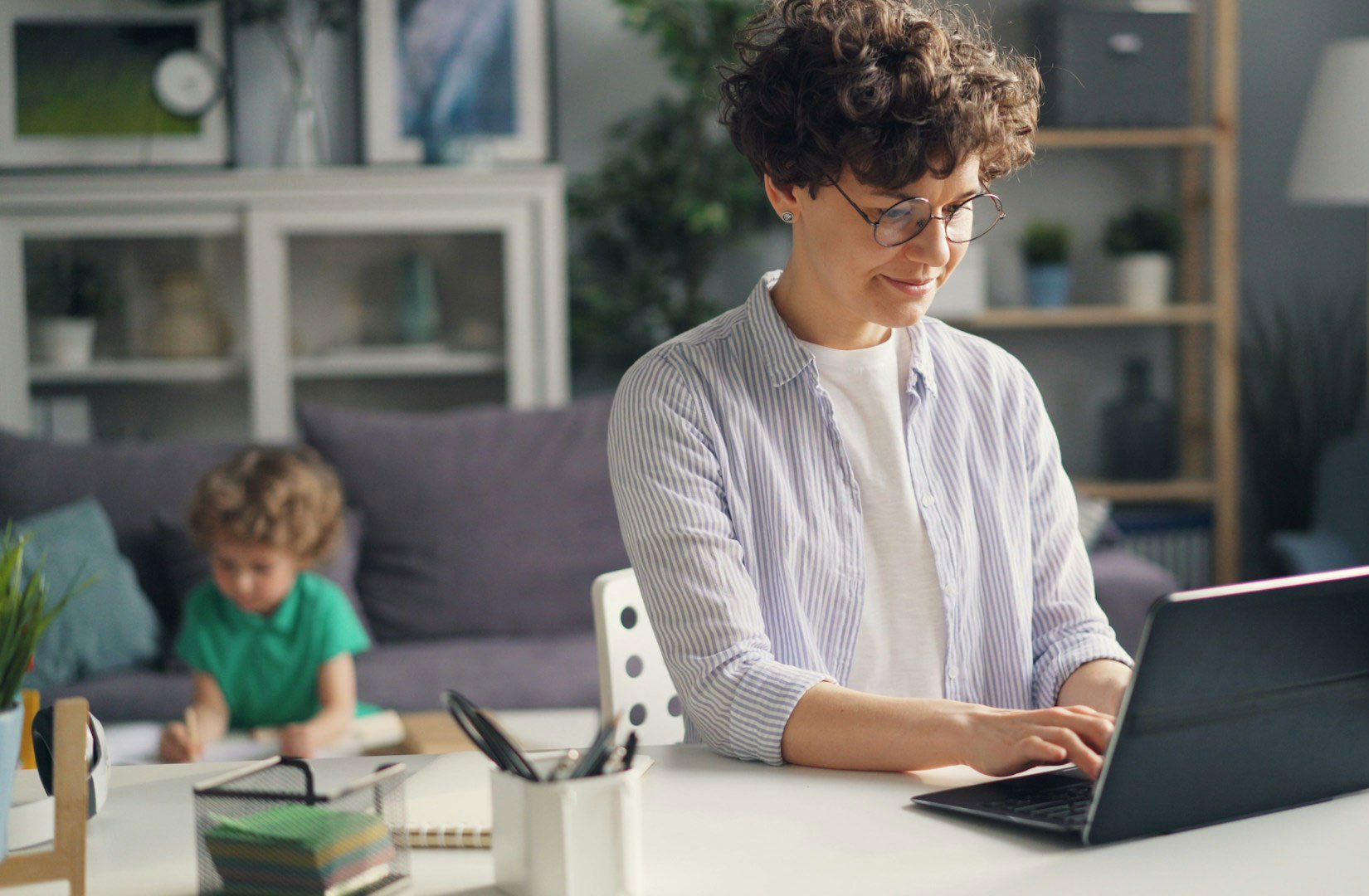 woman using computer with a toddler