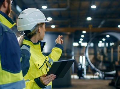 A female in an industrial environment with tablet in hand