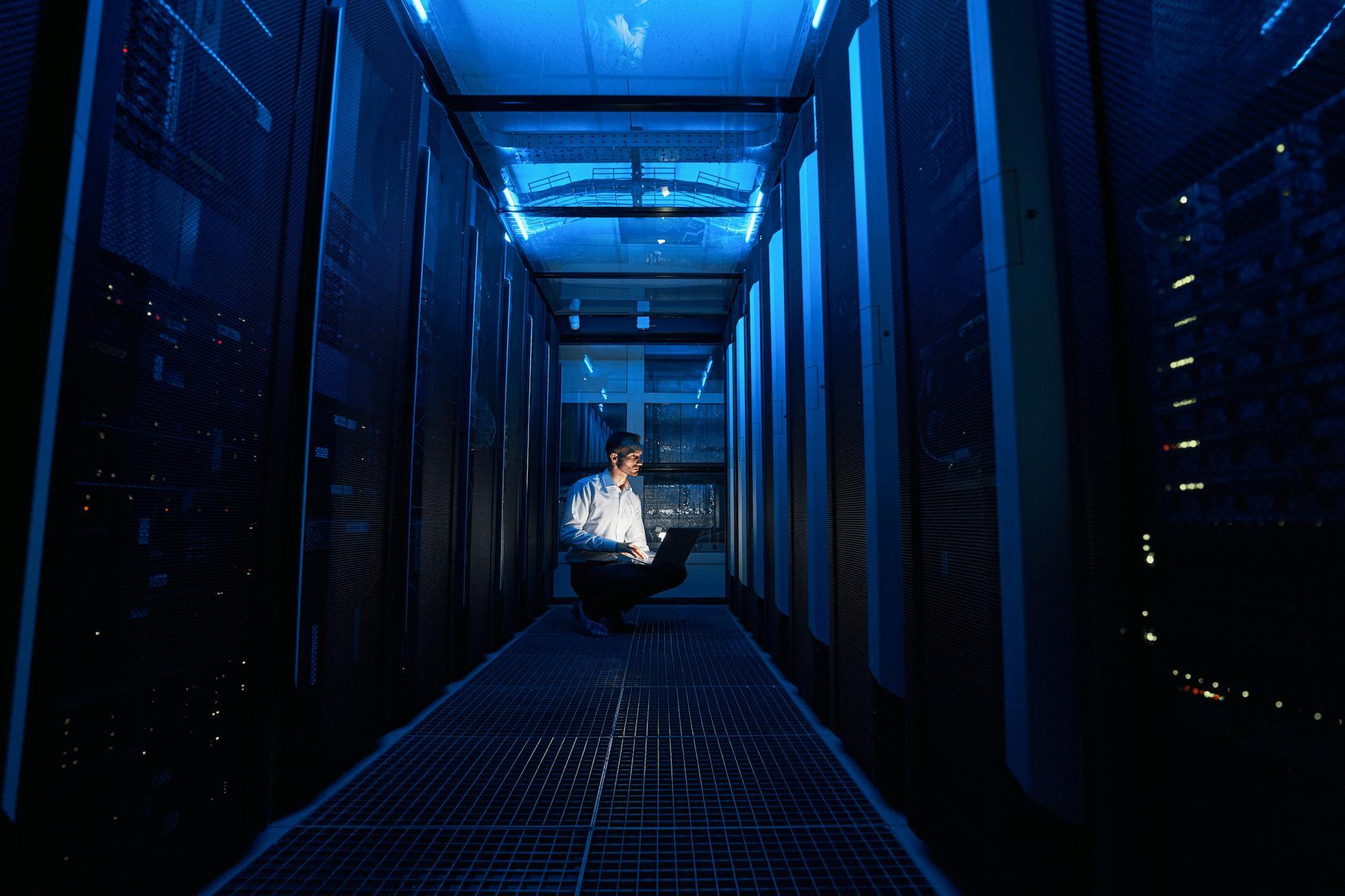 Man in a server room with laptop