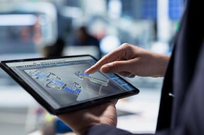 person holding tablet in hand with data on the screen