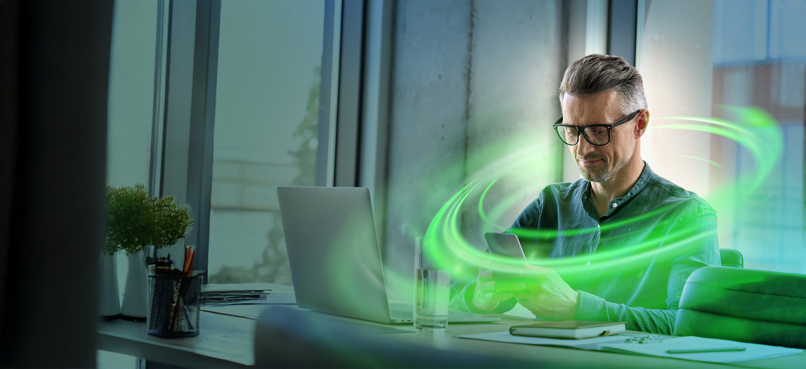 Man sitting in a office, surrounded by green lights
