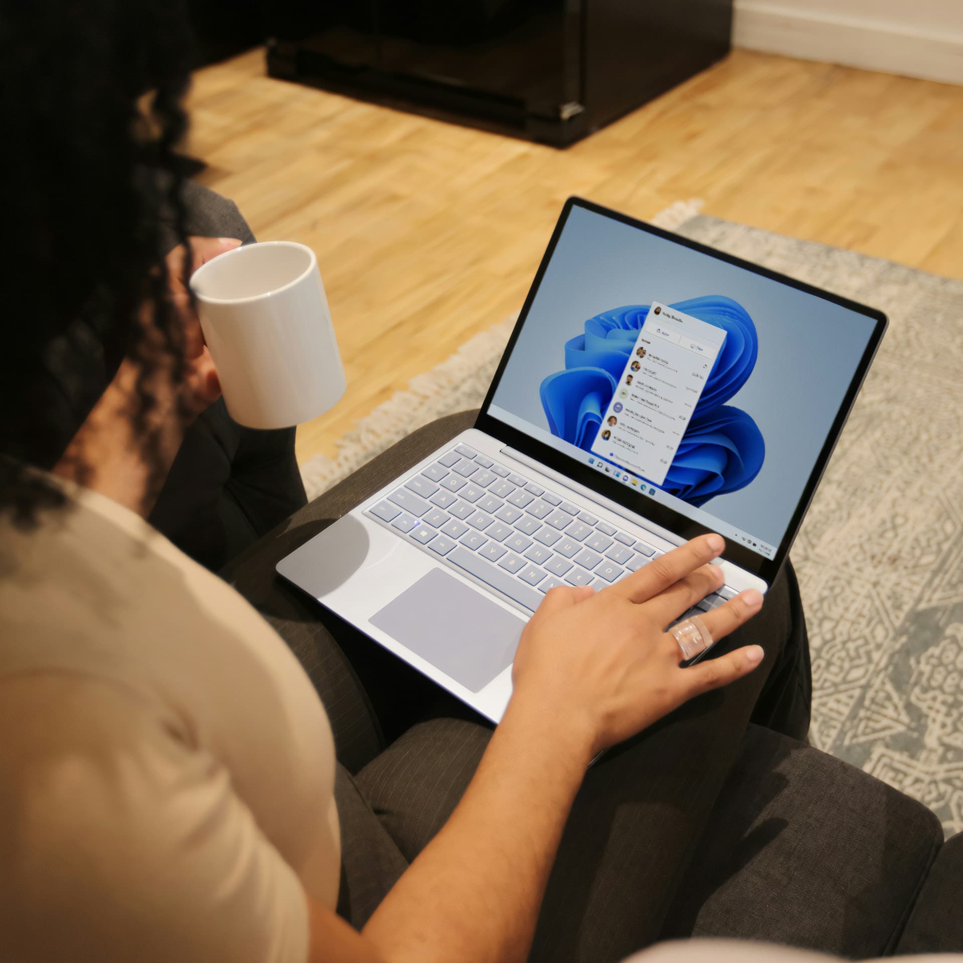 Person using a Microsoft laptop with Windows 11 and Dynamics 365 Copilot interface visible on screen.