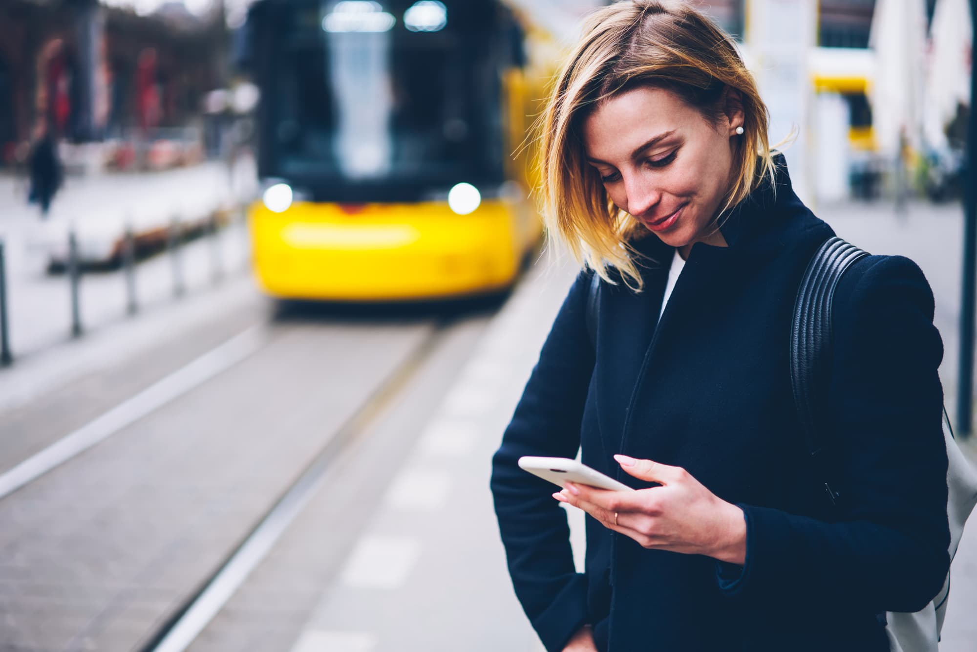 woman with mobile phone at train station