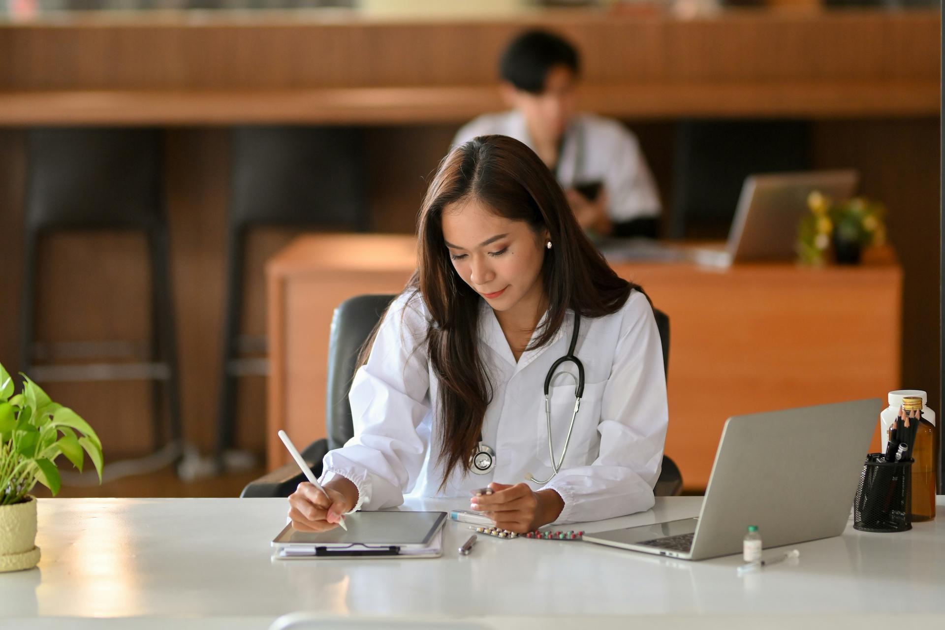 asian female doctor working on computer at desk