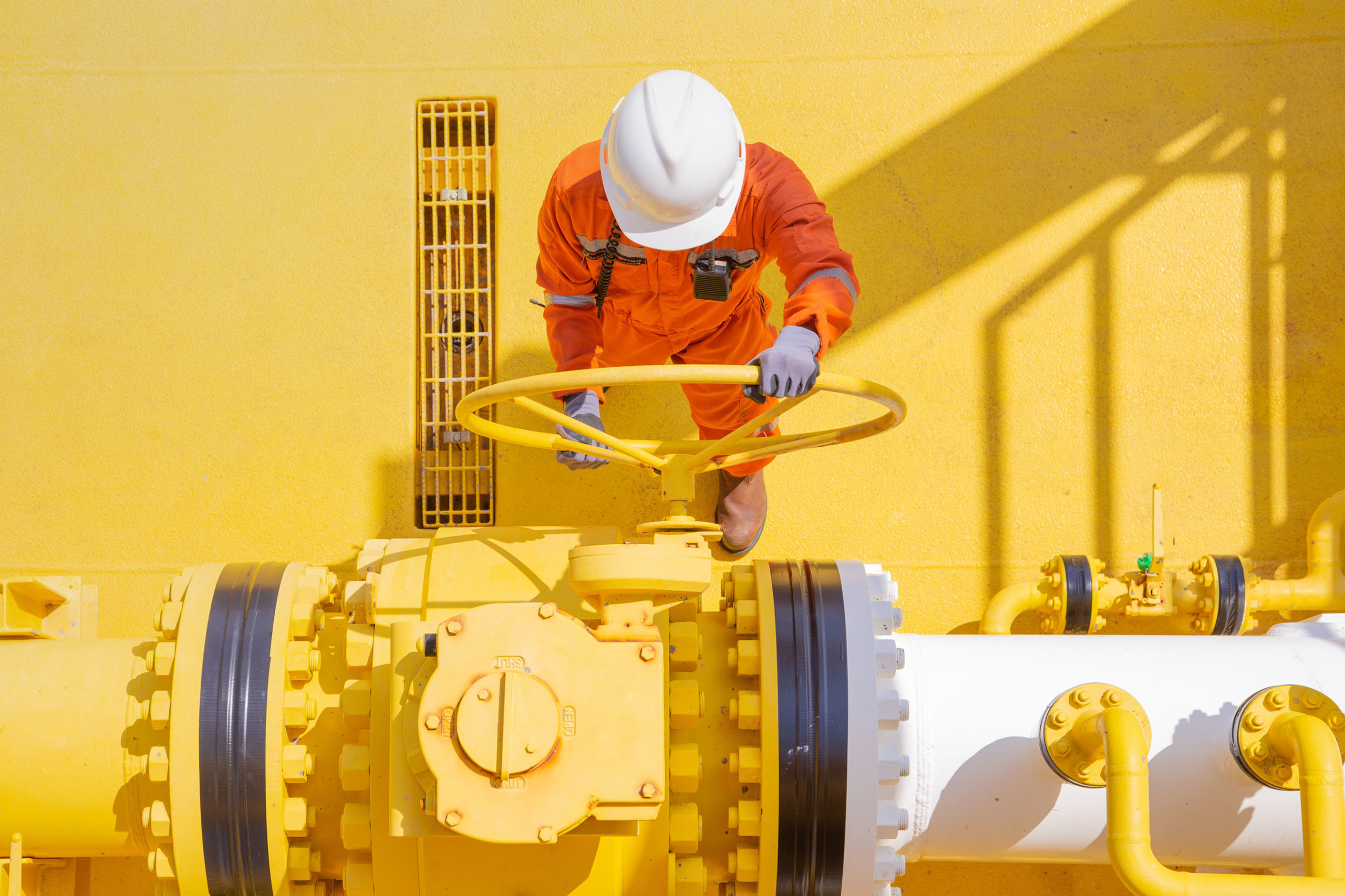 Worker turning oil pipe wheel