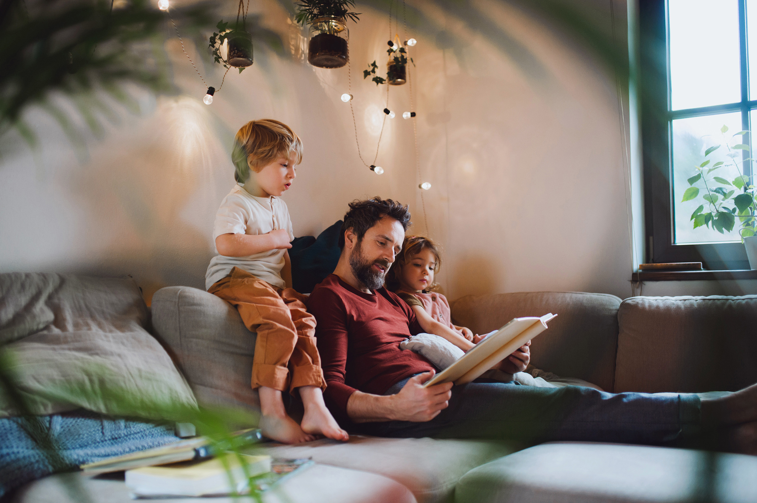 Dad home with two small children reading a book