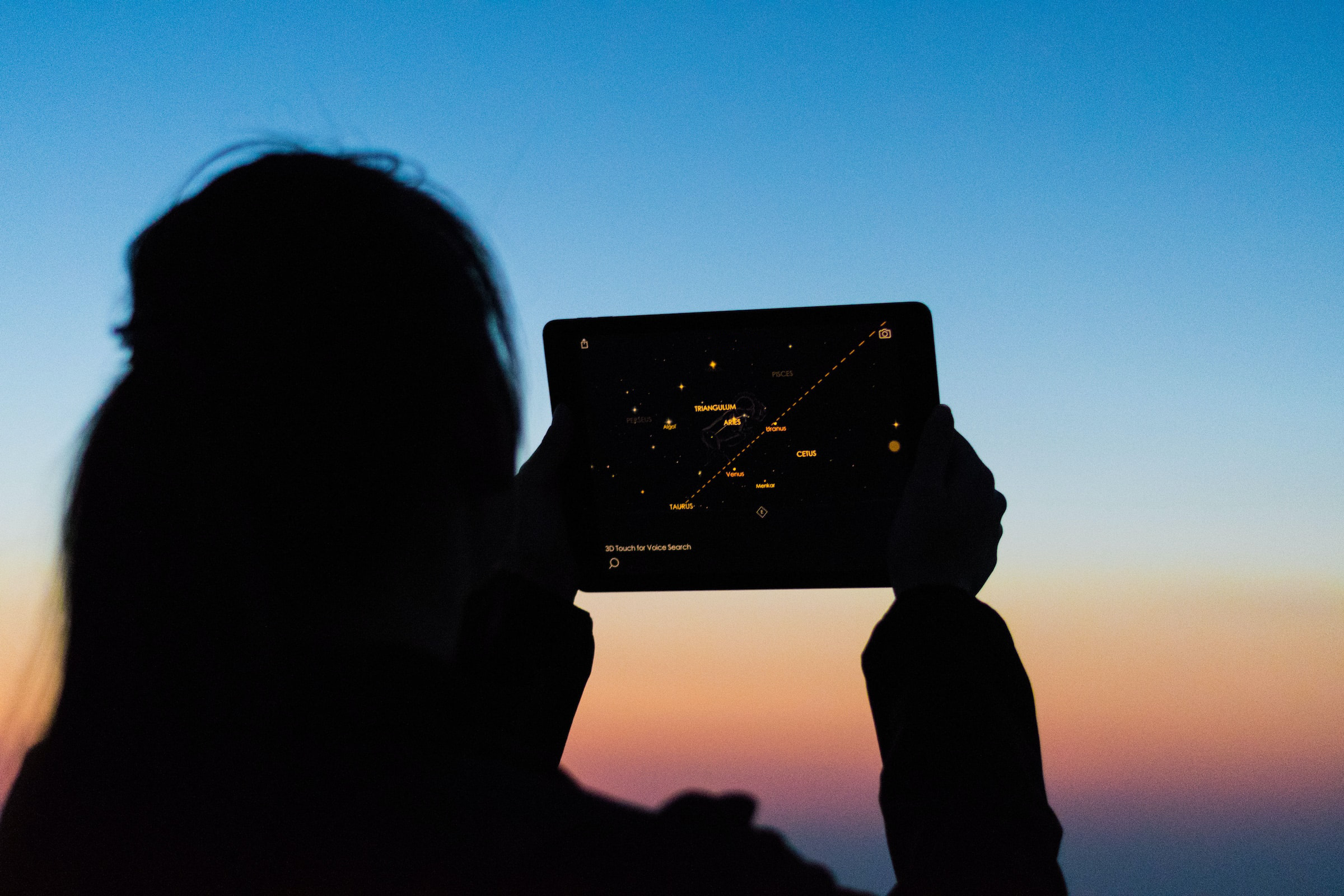 A woman viewing the sky through an app