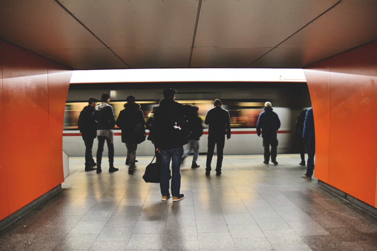 People standing in subway, train passing