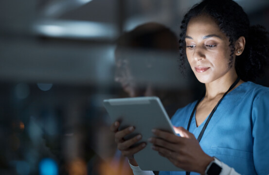 Female doctor holding tablet in the dark