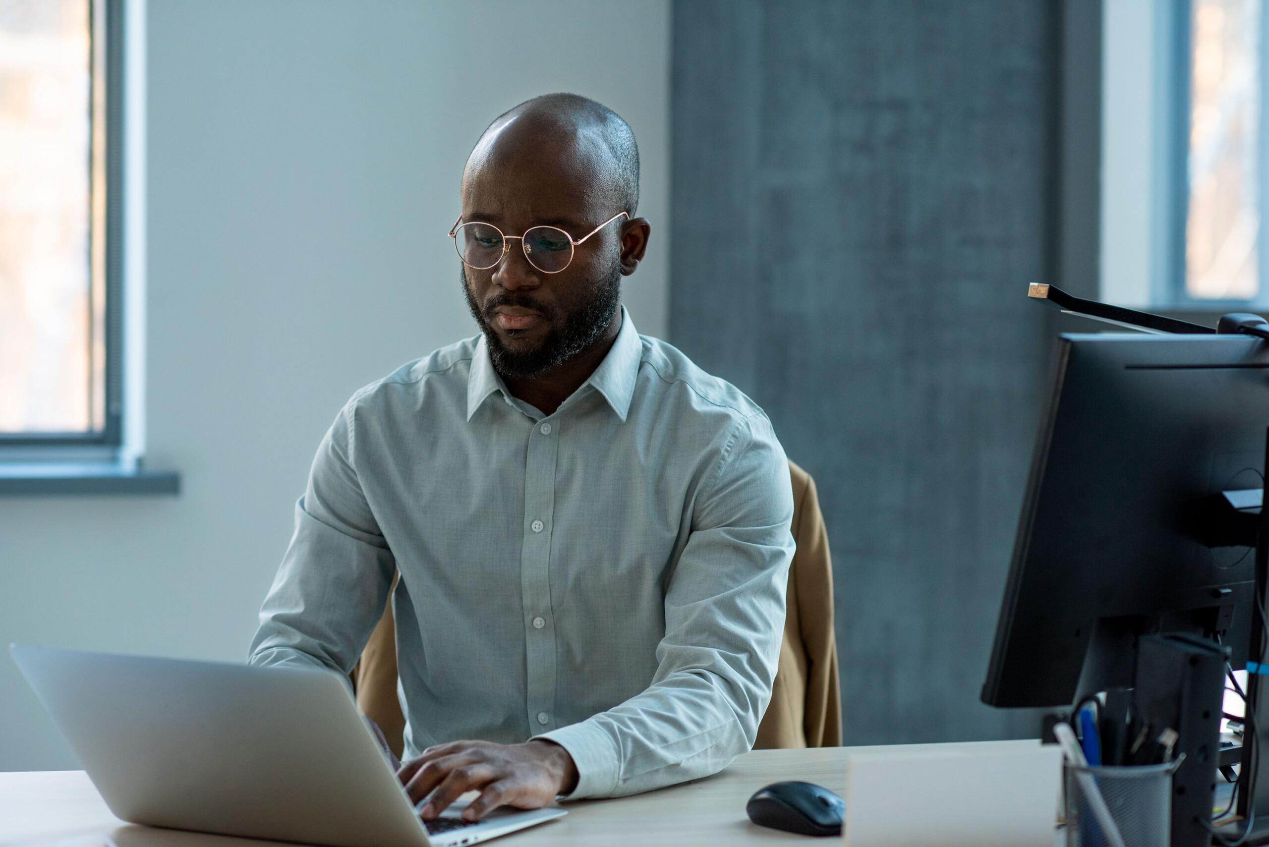 Black man sitting behind computer ar office