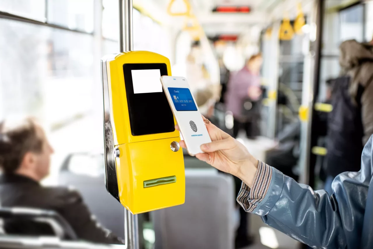Human paying with mobile phone for a bus ticket