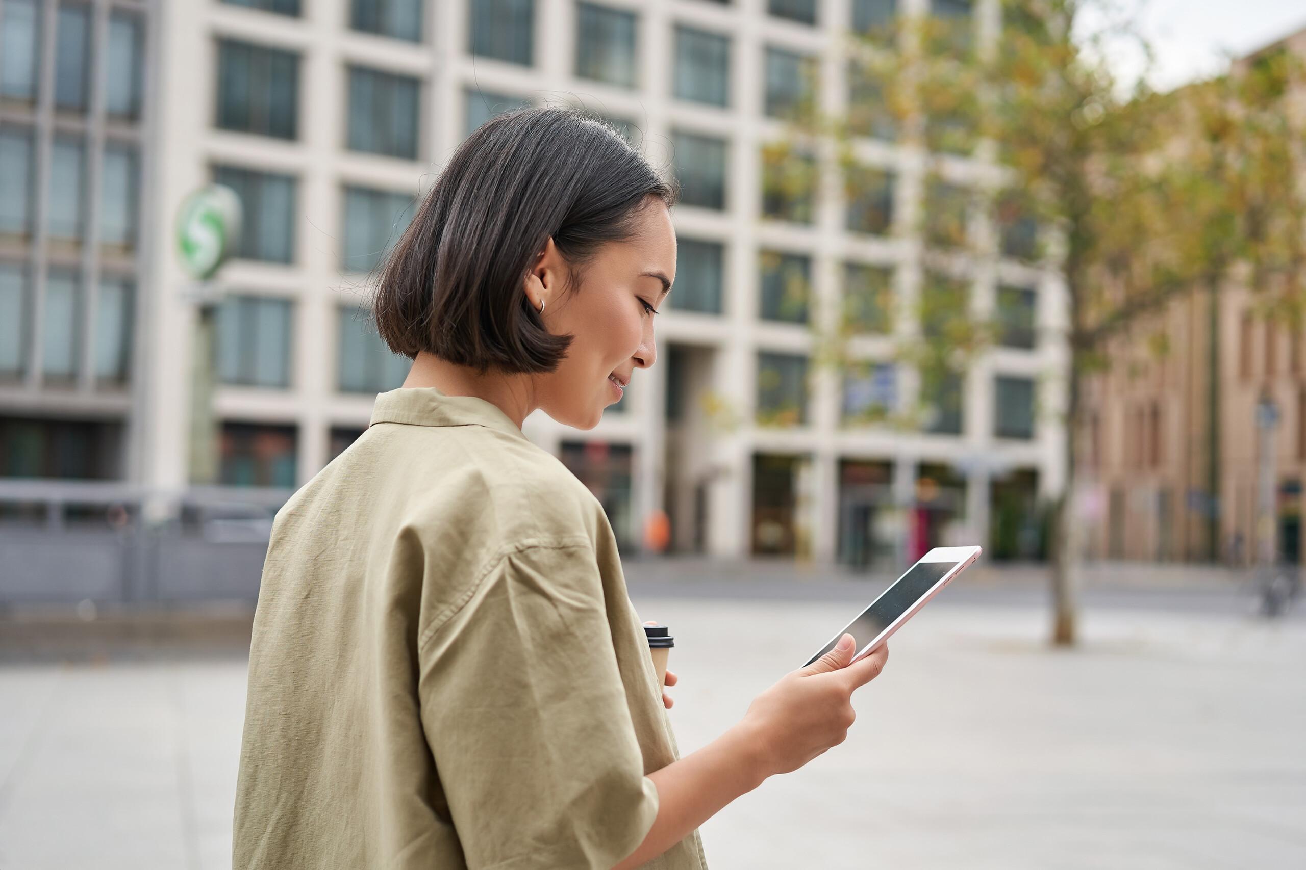 woman walking on the street using smartphone