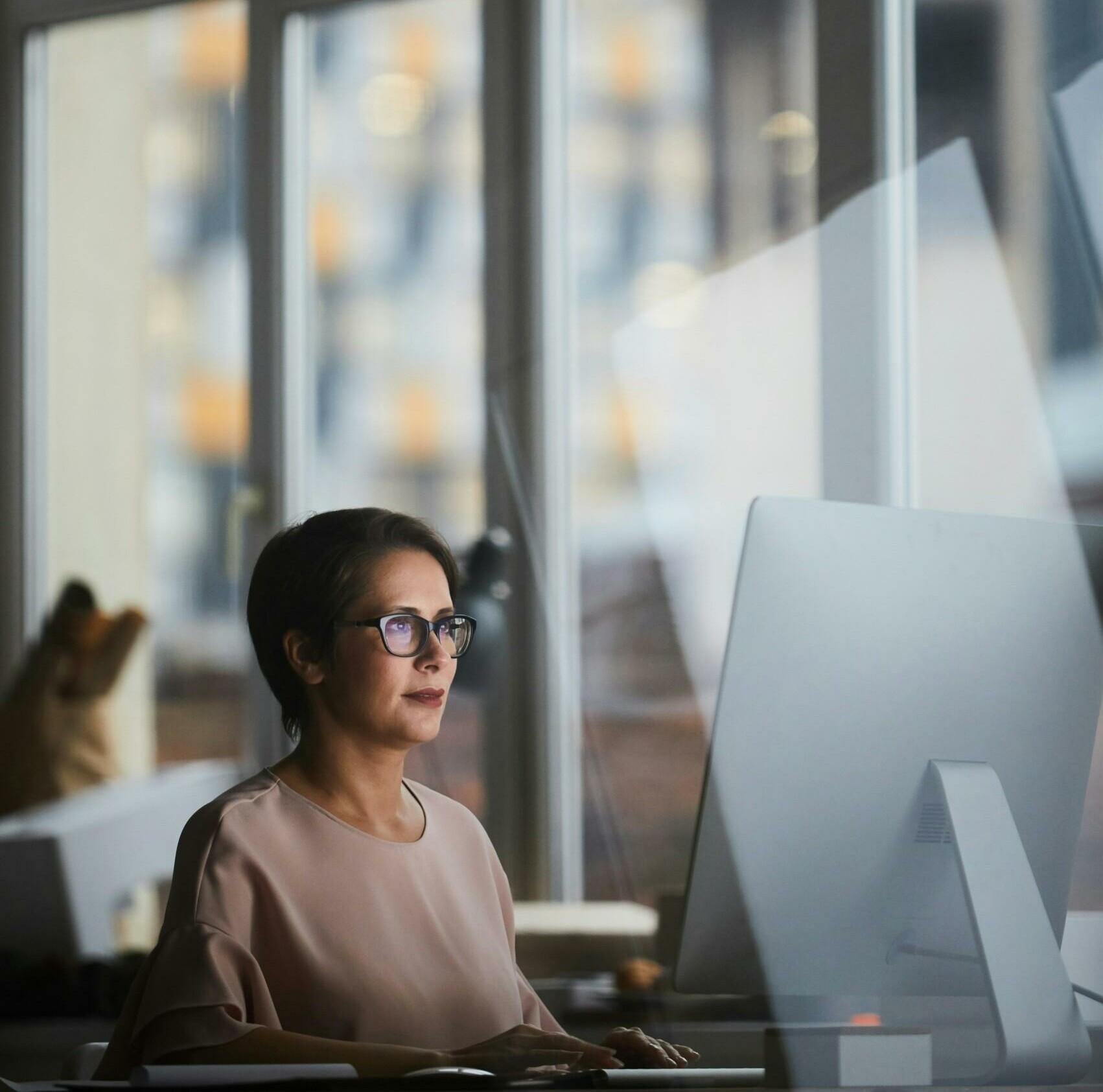 Woman using a computer next to the window