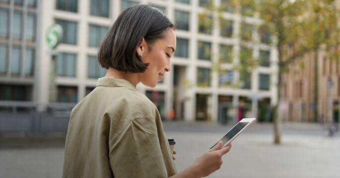 woman walking on a street with a phone