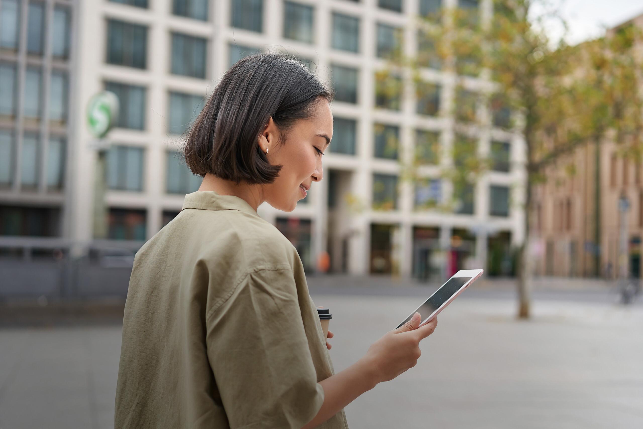 woman walking on a street with a phone